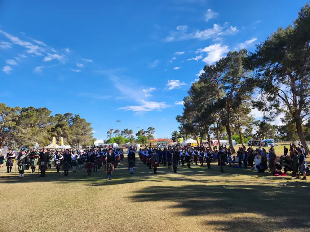 Pipe bands gathered on the park grounds with spectators
